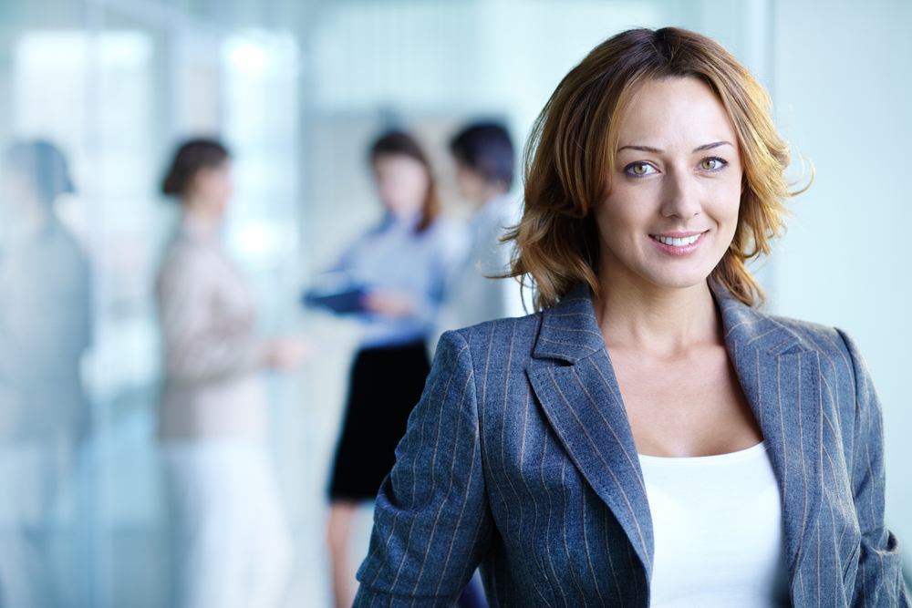 Businesswoman wearing blazer in front of blurred office
