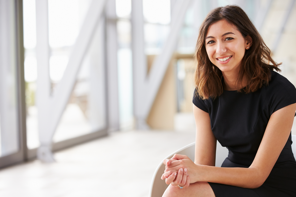 businesswoman sits in front of blurred background