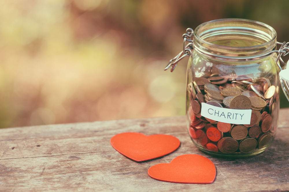 glass jar labeled charity with plastic hearts