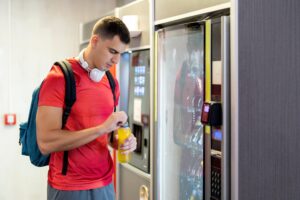 athlete opening drink from vending machine