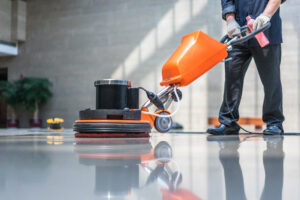 person cleaning floor with a machine